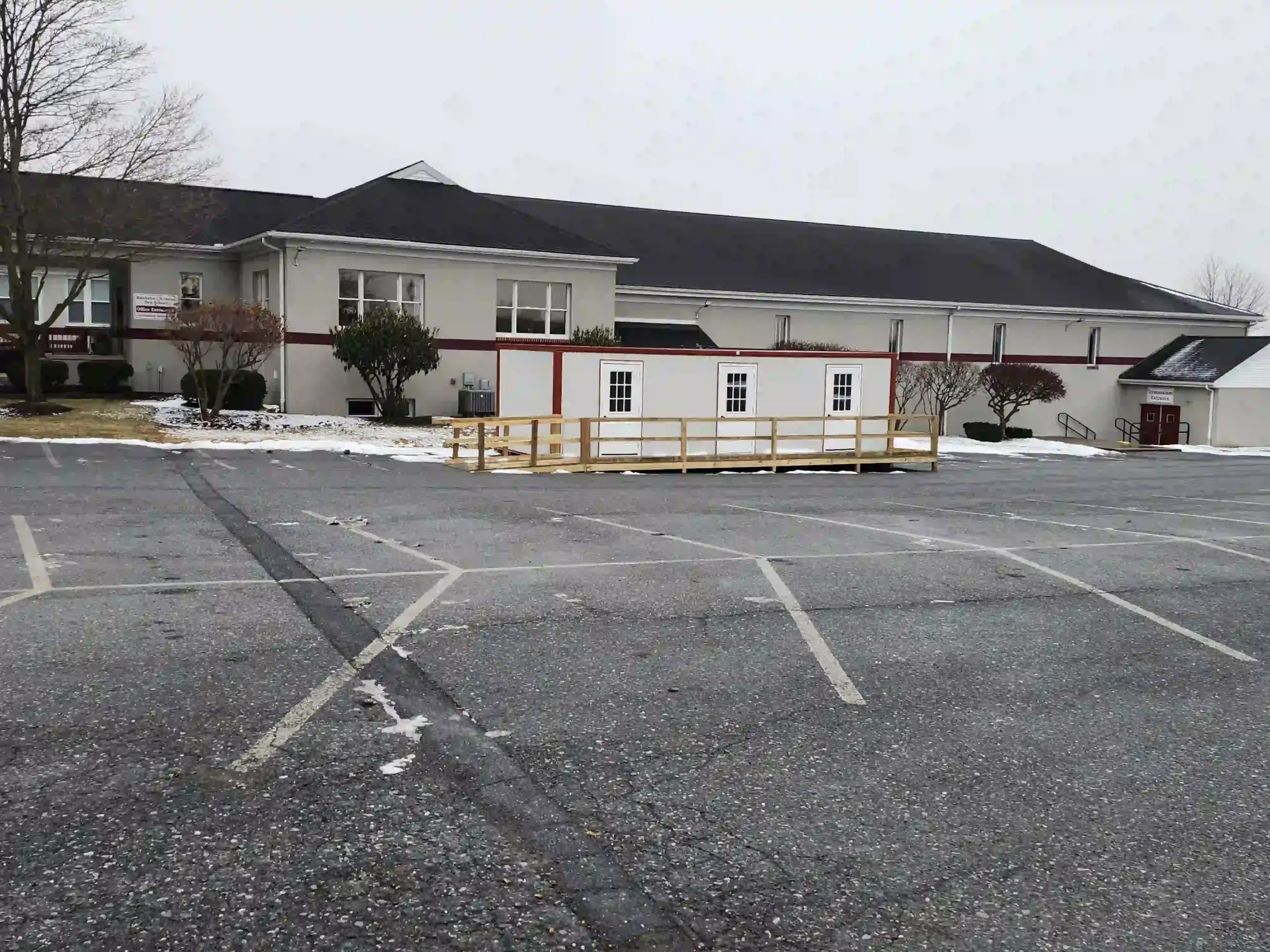 A temporary classroom or office building with an accessibility ramp installed in the parking lot of a church in Pennsylvania.
