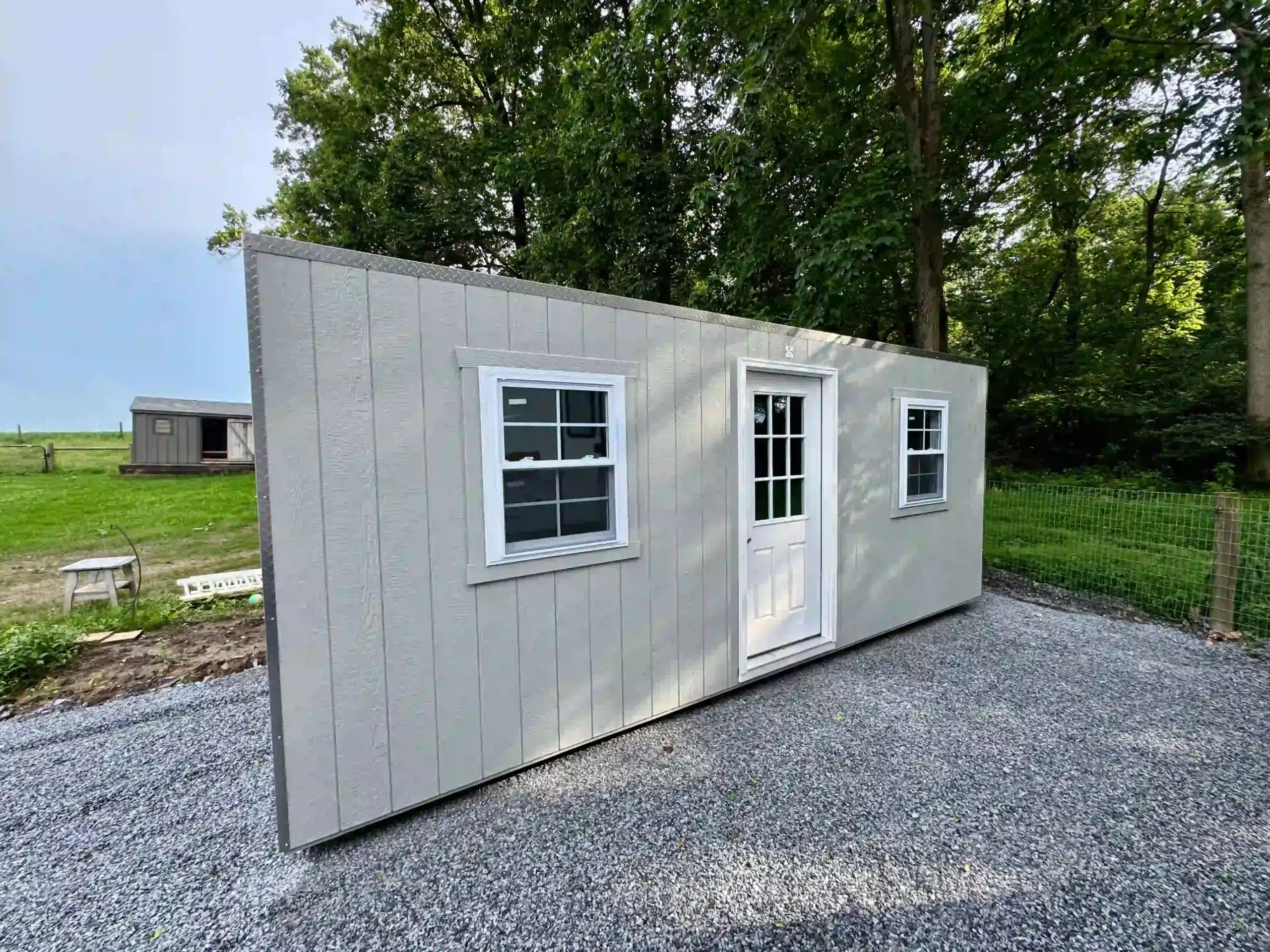 A modern portable office shed with a glass-paned door and windows, installed on a new gravel pad in Pennsylvania by Mill Run Storage.