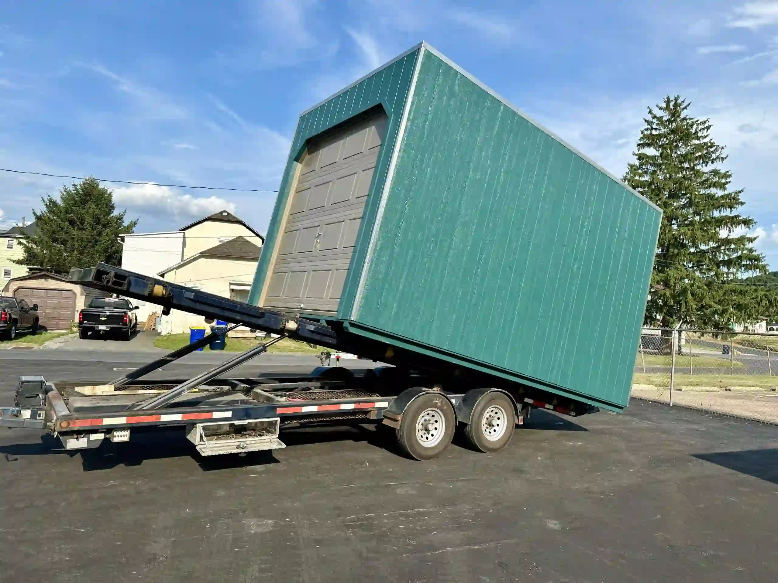 Our specialized tilting delivery trailer makes unloading a portable garage a smooth and controlled process.