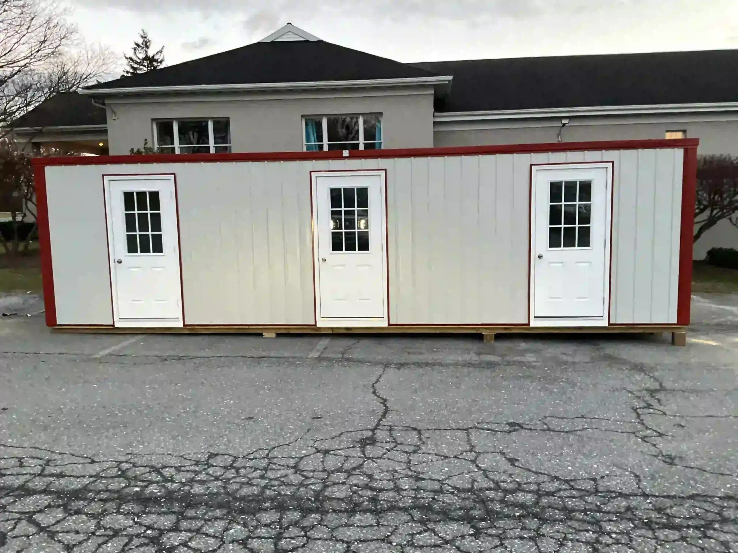 A large, multi-entrance portable classroom or office building immediately after being placed on-site by Mill Run Storage.