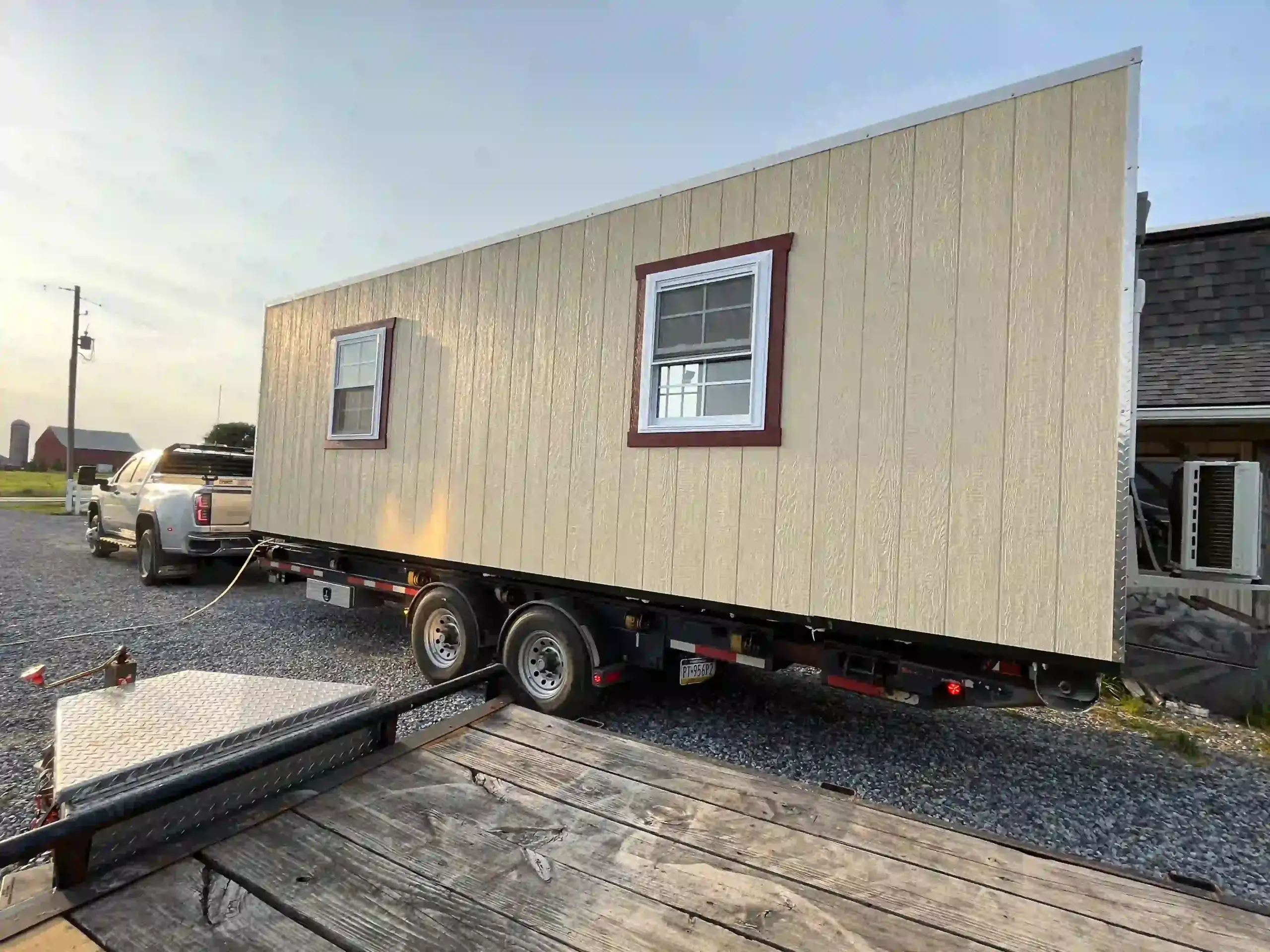 A large, custom-built portable office building loaded onto a specialized trailer for delivery in Pennsylvania by Mill Run Storage.