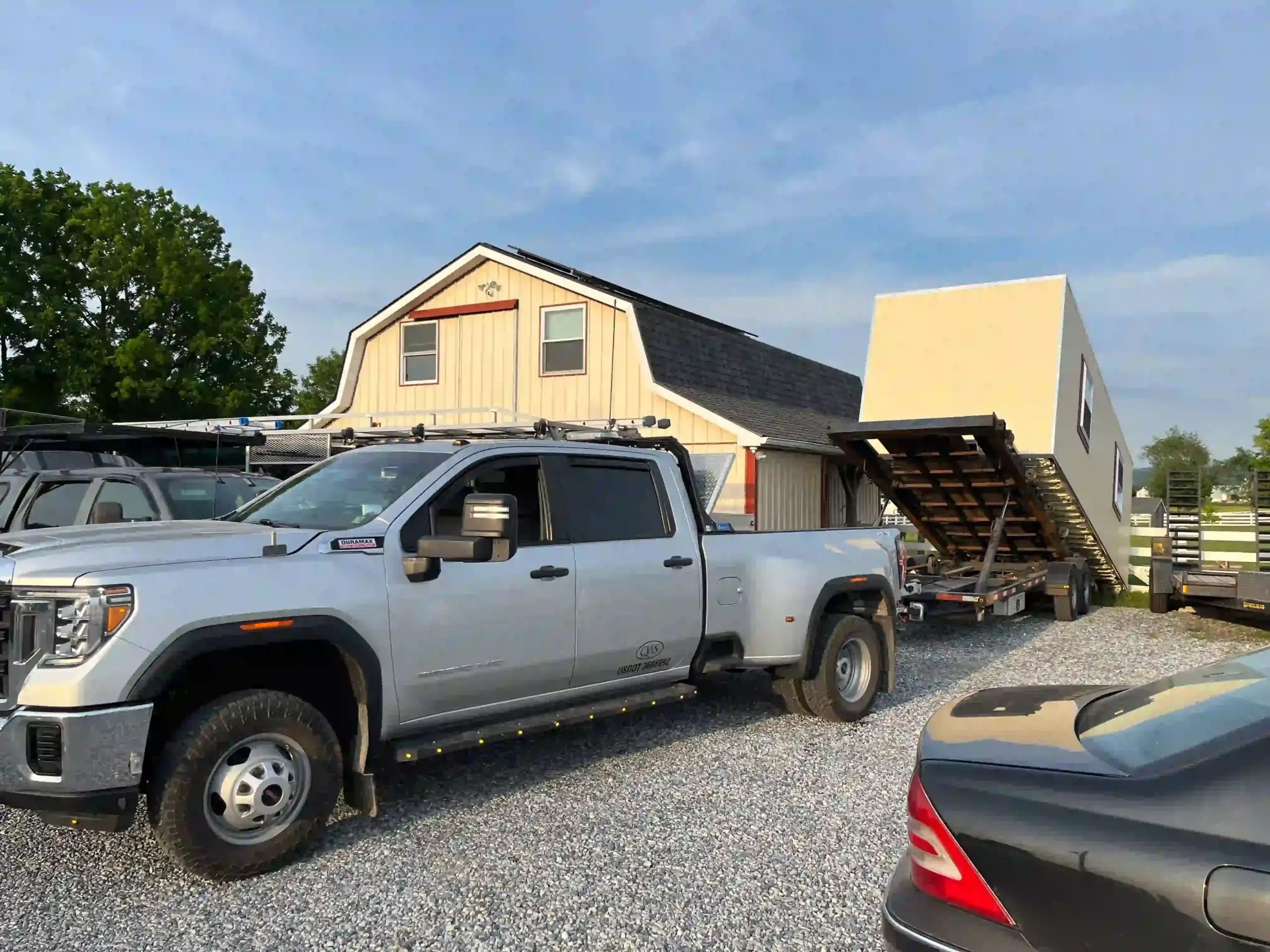 Our specialized tilt-trailer carefully unloading a large portable building at a customer's location in Lancaster County.