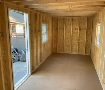 The high-quality interior framing of an Amish-built shed, showing the sturdy wall studs and construction before finishing.