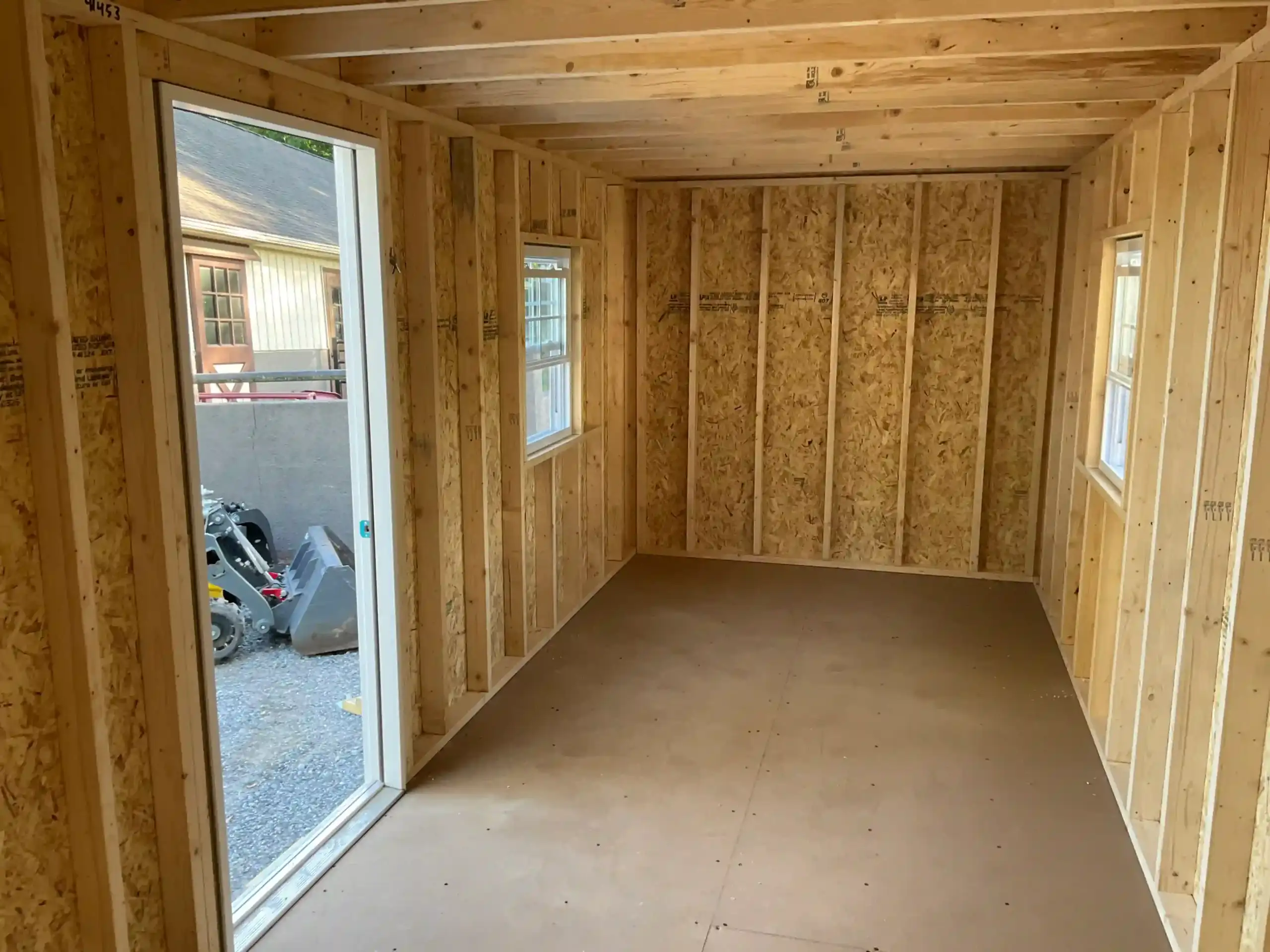 The high-quality interior framing of an Amish-built shed, showing the sturdy wall studs and construction before finishing.