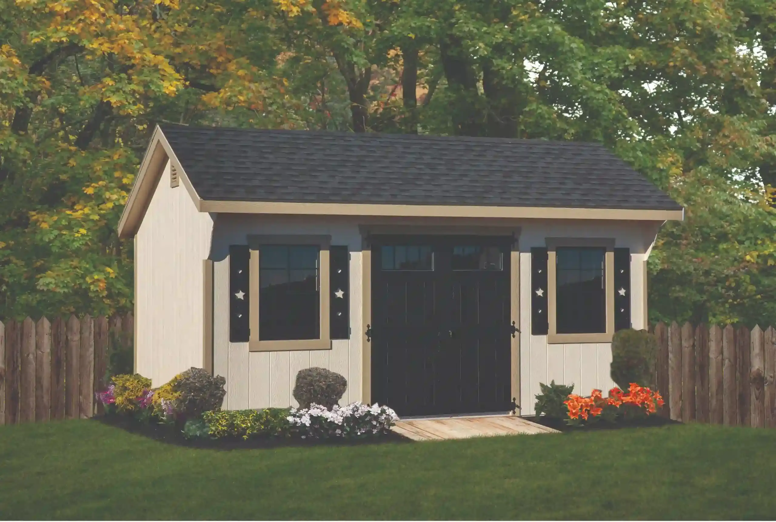 A unique cream-colored storage shed featuring decorative black shutters with star cutouts and matching doors with transom windows.