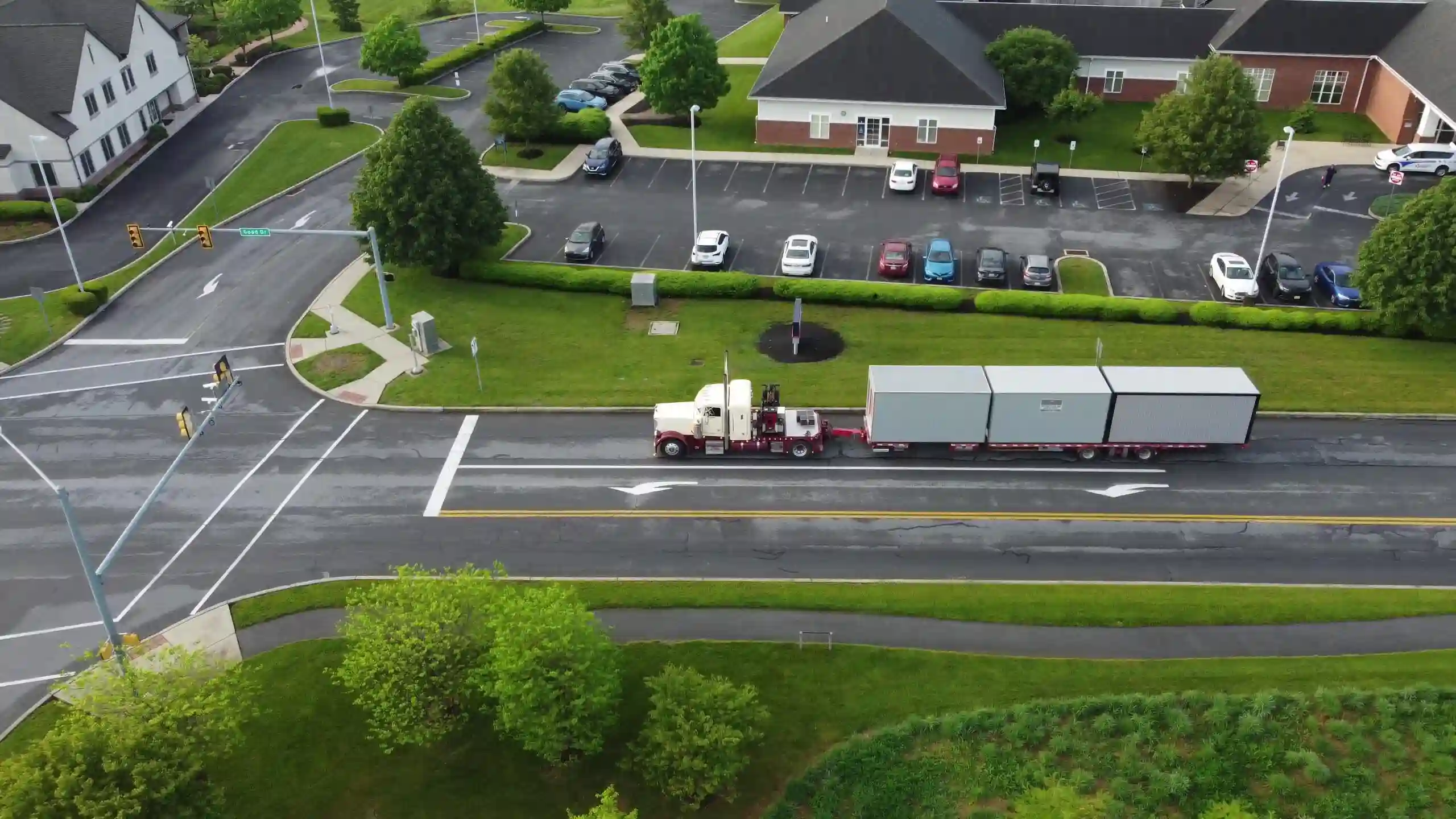 An aerial drone view of a Mill Run Storage semi-truck transporting two portable storage units for a commercial client in Pennsylvania.
