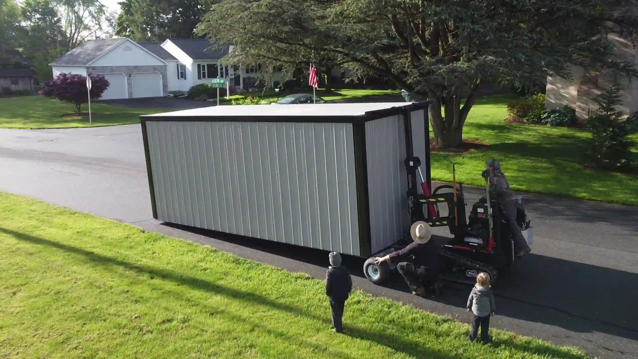 A high-angle view of our professional team guiding the shed mover for a precise and safe delivery.