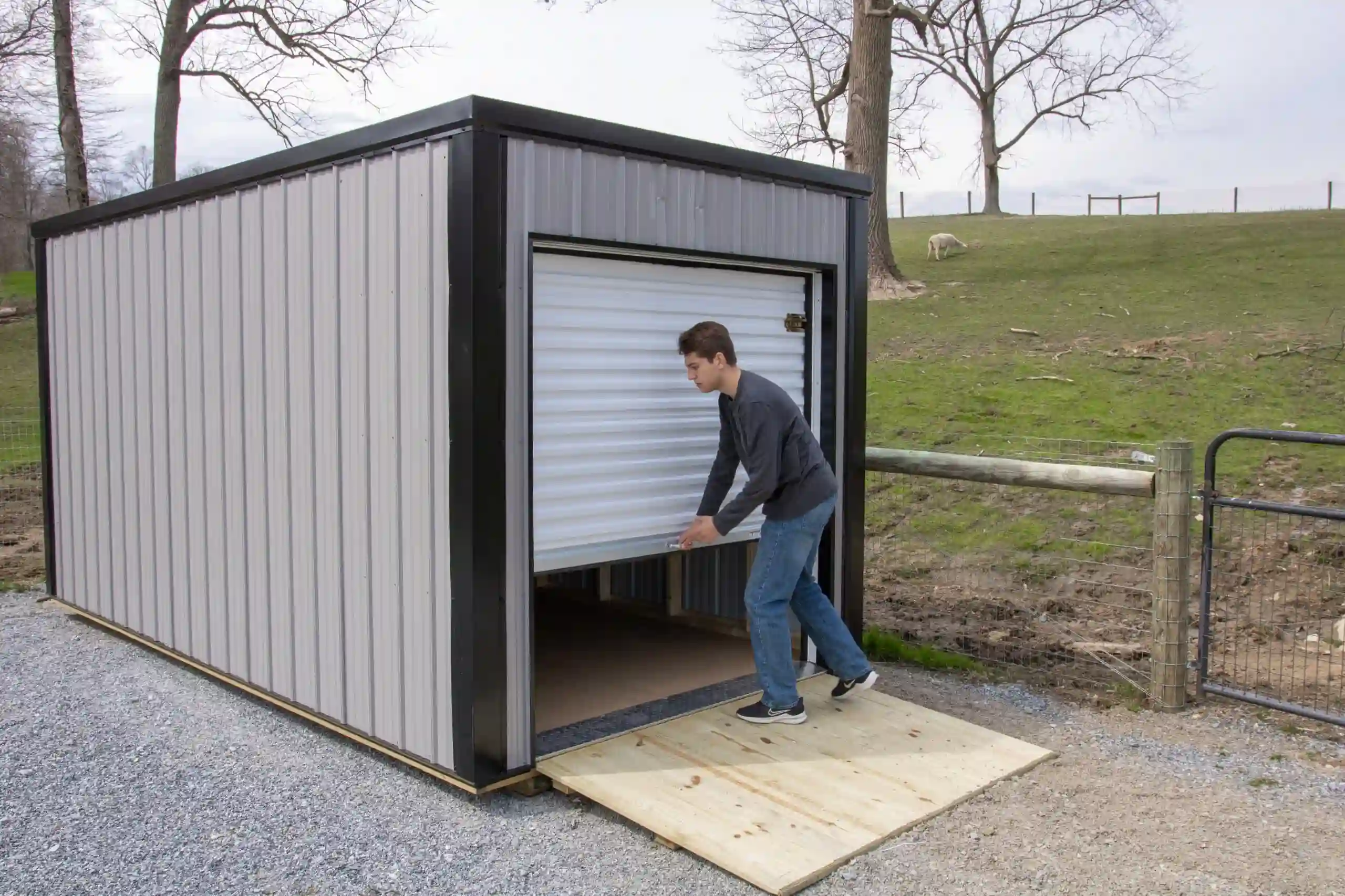 A man easily closing the secure, roll-up door on a portable storage unit from Mill Run Storage.